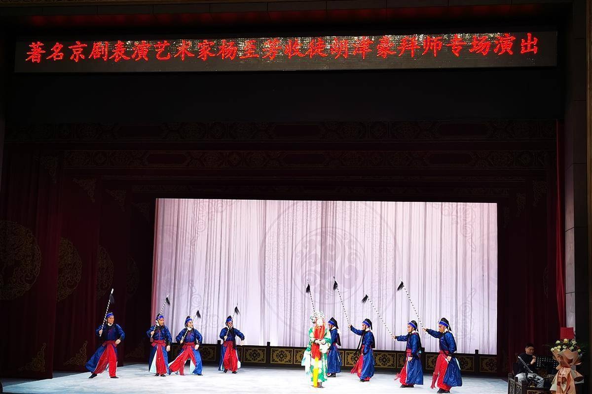 名家杨至芳收徒专场惠民演出舞台全景，背景LED横幅作「著名京剧表演艺术家杨至芳收徒胡津豪拜师专场演出」