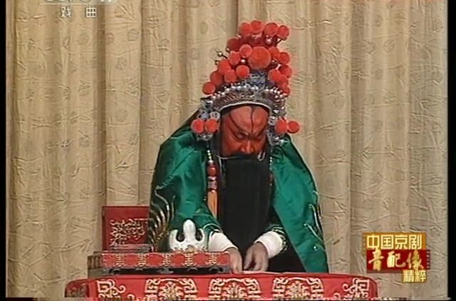 京剧《灞桥挑袍》音配像截帧：汪庆元配像饰关羽，坐案修书