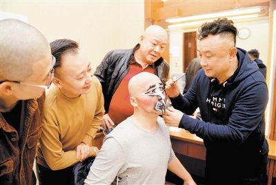 专场演出前，石晓亮（右一）为弟子权守昌（右二）扮戏（天津市文化和旅游局）