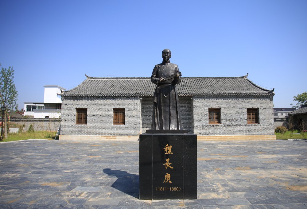 潜山市王河镇程家井村程长庚故居院内的程长庚纪念雕像（基座铭文「程長庚（1811—1880）」；今人纪念塑像，非本人影像）