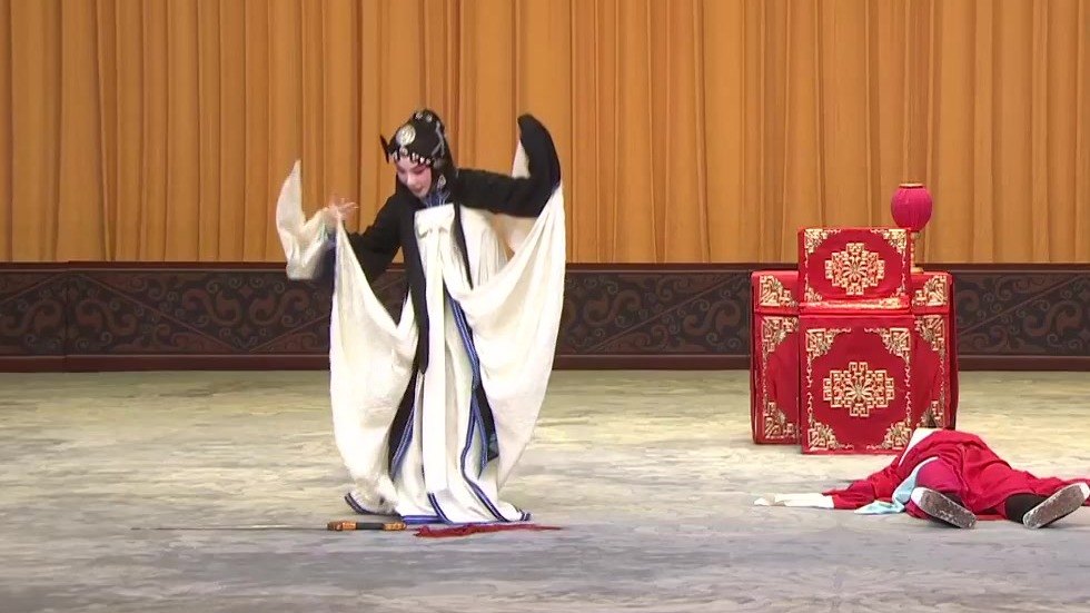 京剧《审头刺汤》「刺汤」录像截帧：雪艳（旦，左）与被刺倒地的汤勤（丑，右）
