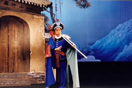 京剧《野猪林》剧照：布景门额作「山神庙」，林冲持枪立于庙前（国家京剧院官网剧目页所载）